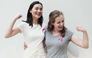 Zwei junge Frauen mit der rosa Schleife gegen Brustkrebs