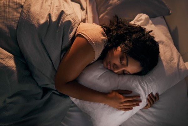 Eine Frau schläft nachts in ihrem Bett
