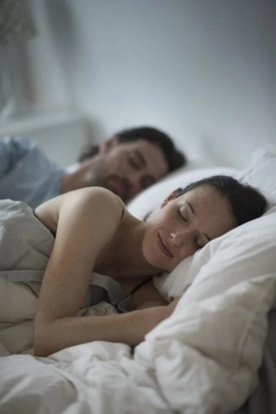Paar schläft nebeneinander im Bett