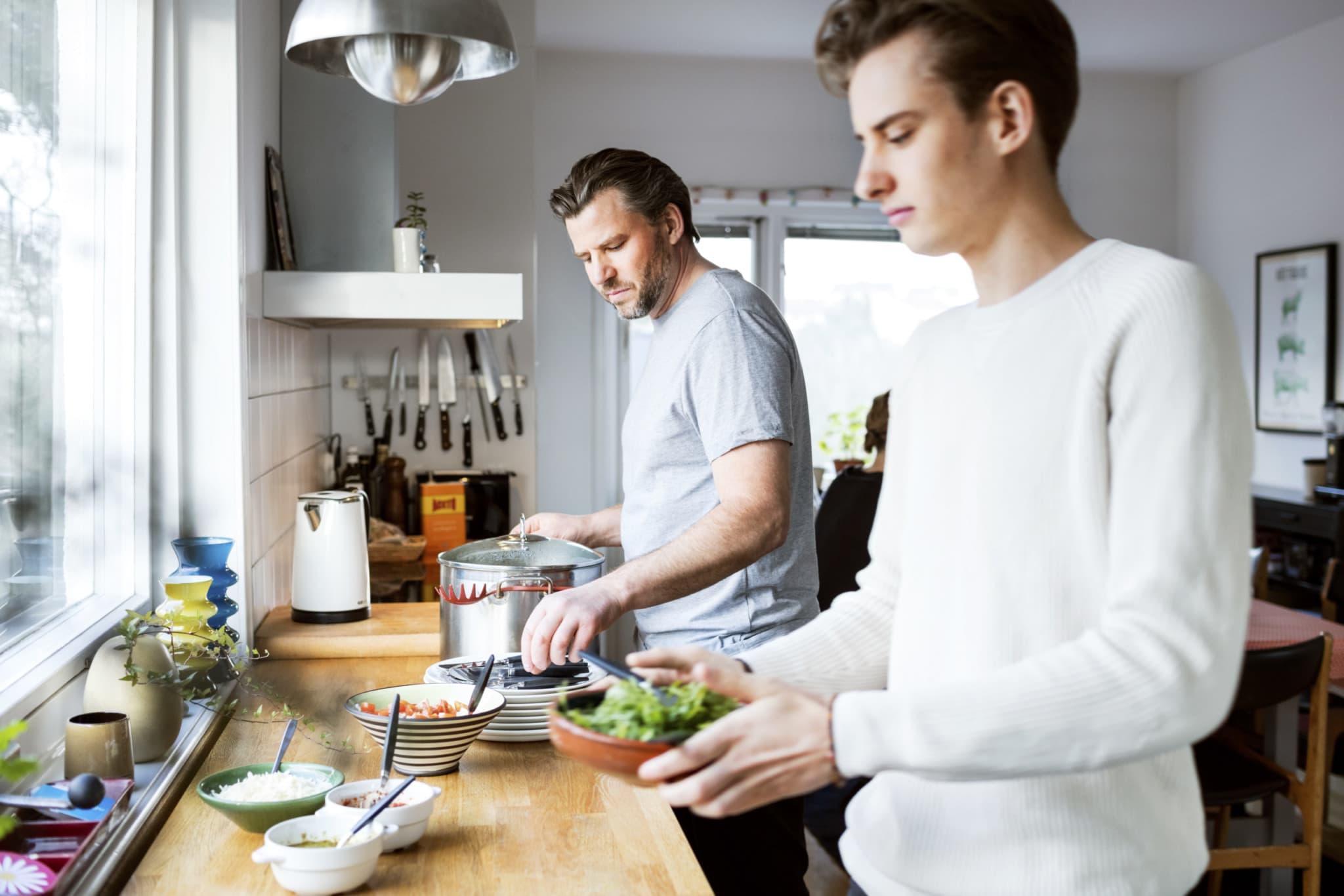 Vater und Sohn reden beim Kochen über Magersucht bei Männern