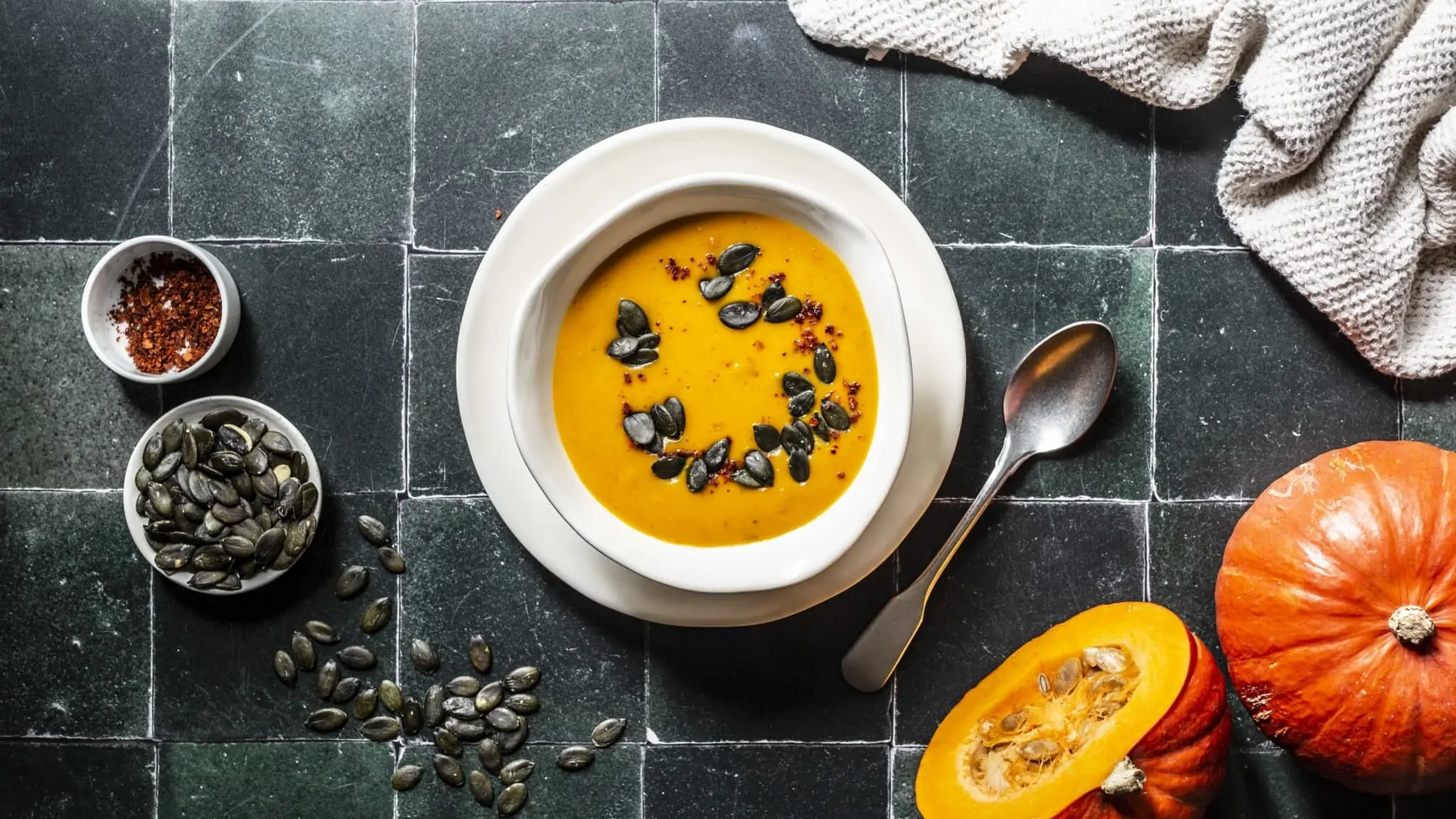 In einer Schüssel ist eine Kürbissuppe mit Kokosmilch und Orangensaft serviert.