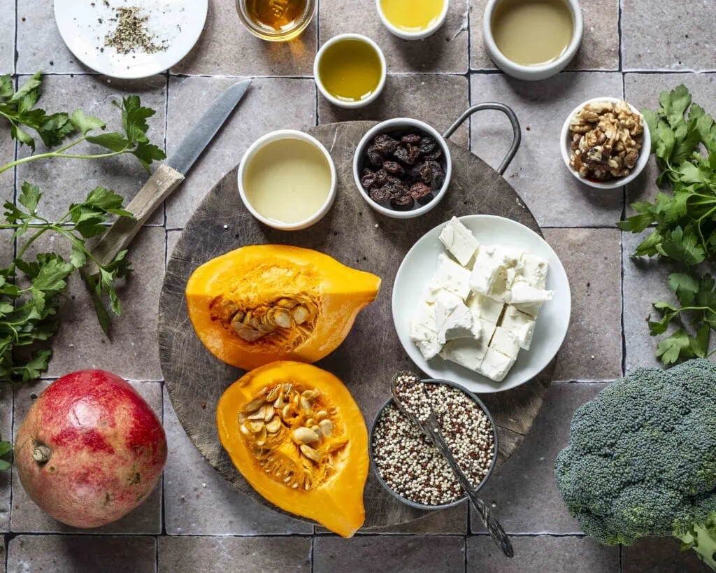 Alle Zutaten für den Quinoa-Salat mit Granatapfel und Brokkoli stehen auf einem Brett bereit.