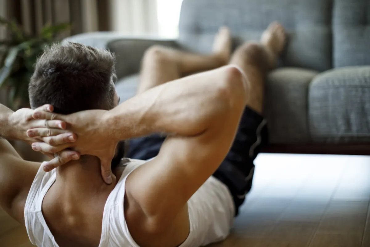 Mann kann Lendenwirbelsäule stärken mit Situps und weiteren Übungen