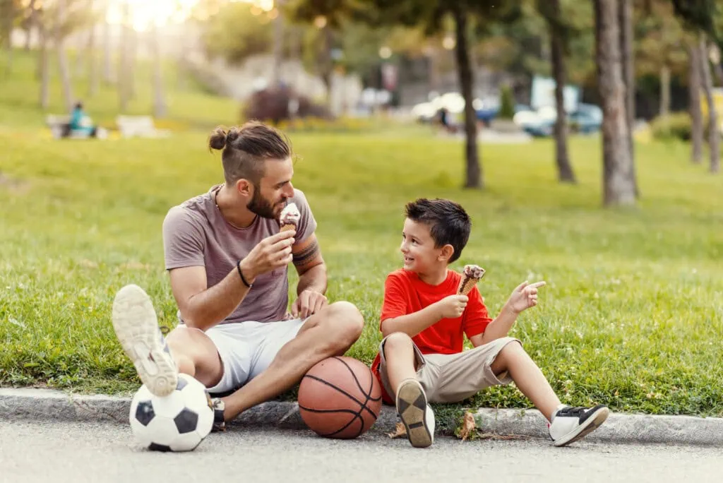 Ein Mann mit seinem Sohn beim Eis essen - wann zum Arzt beim Wespenstich?