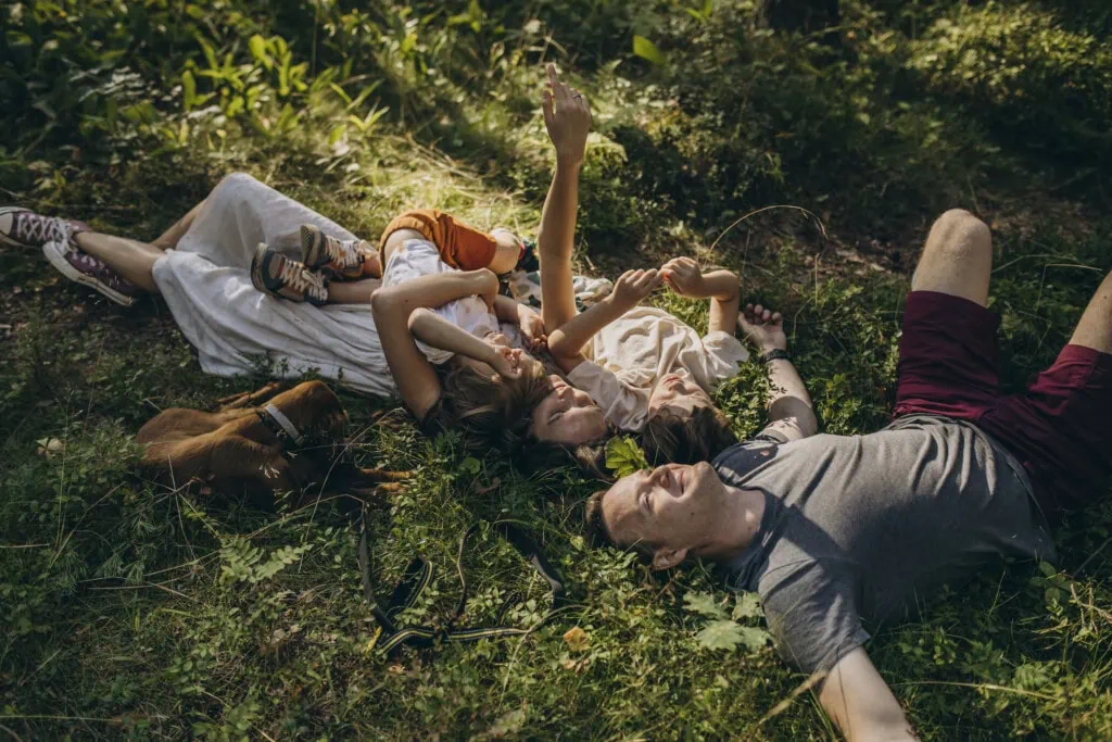 Eine Familie im Gras - wann zum Arzt beim Zeckenbiss?