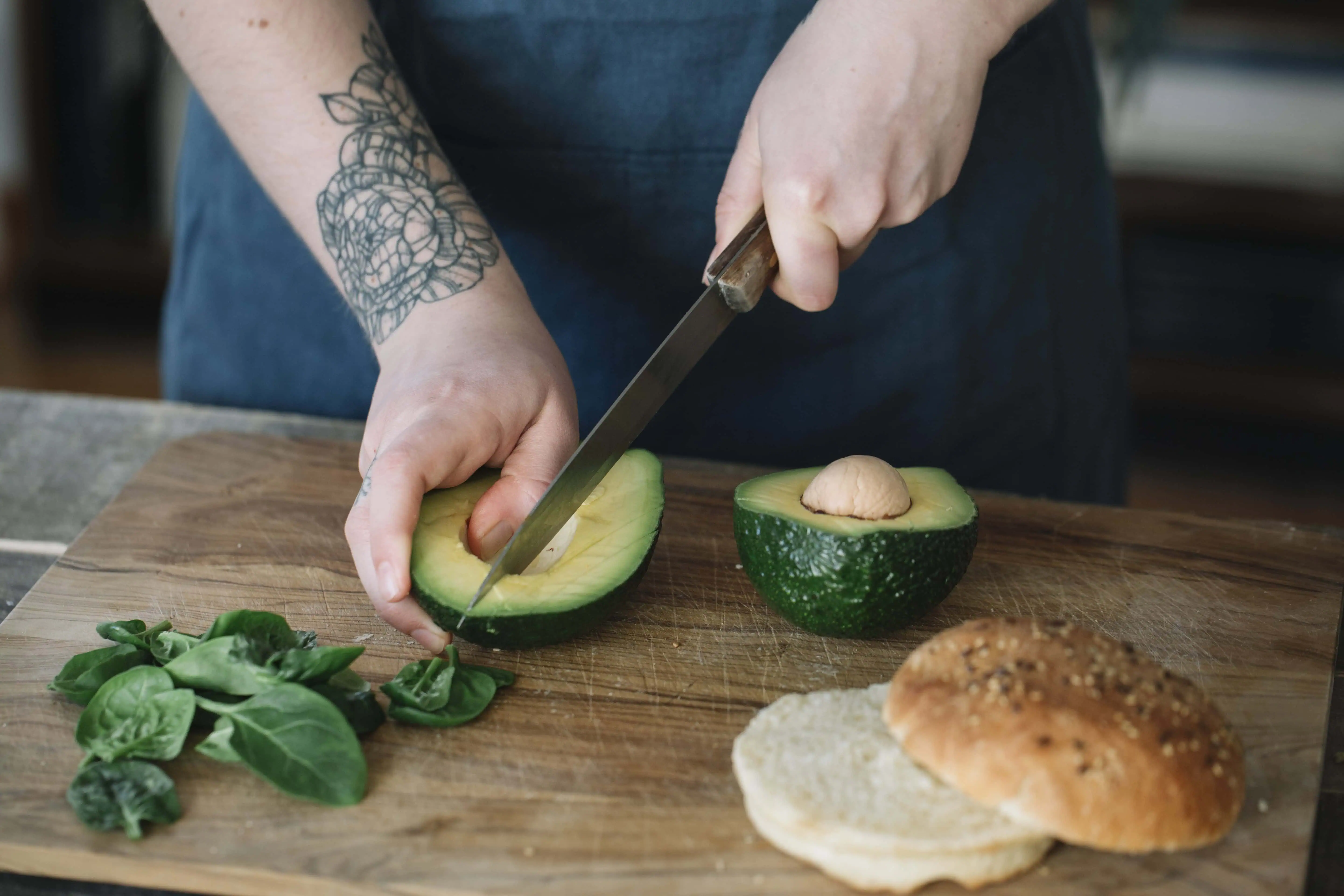 Eine Frau schneidet Avocado als Teil ihrer Ernährung während des Zyklus