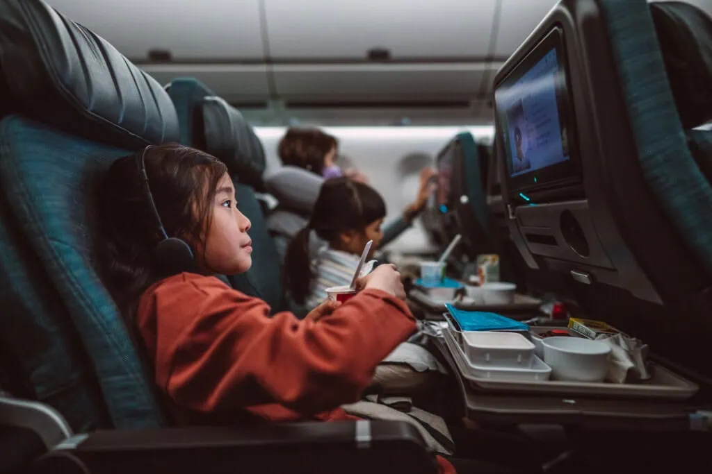 Ein junges Mädchen im Flugzeug - bei Kindern sollte der Druckausgleich im Flugzeug spielerisch erleichtert werden